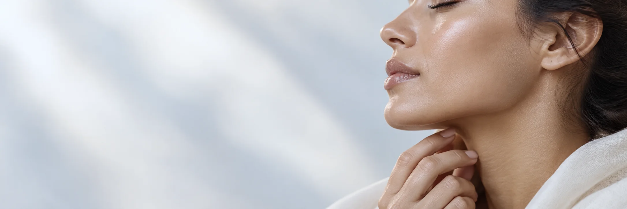 Profile of a woman with dark hair and closed eyes, her fingertips resting below her jaw